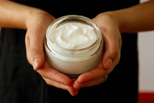 DIY Hydrating Body & Face Cream Go Native NZ recipe in a glass jar held in the palm of womans hands